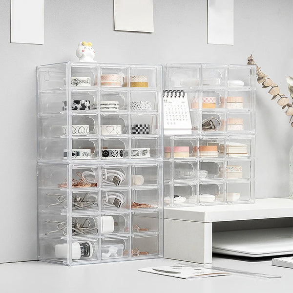 Multiple sets of clear drawers holding office supplies - washi tape, binder clips, keys and even a small stapler. 